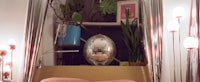 a bed in a room with a disco ball hanging from the ceiling