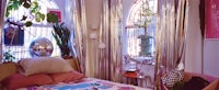 a bed in a room with silver curtains