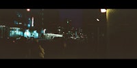 a blurry image of people walking down a city street at night