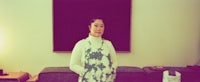 a woman standing in front of a painting