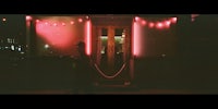 a person standing in front of a red lit door