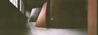 a person is standing in a room with large metal sculptures