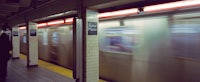 a person standing next to a subway train
