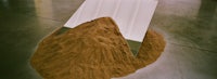 a pile of sand with a white piece of paper on top