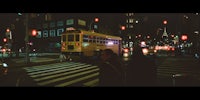 two people crossing a street at night